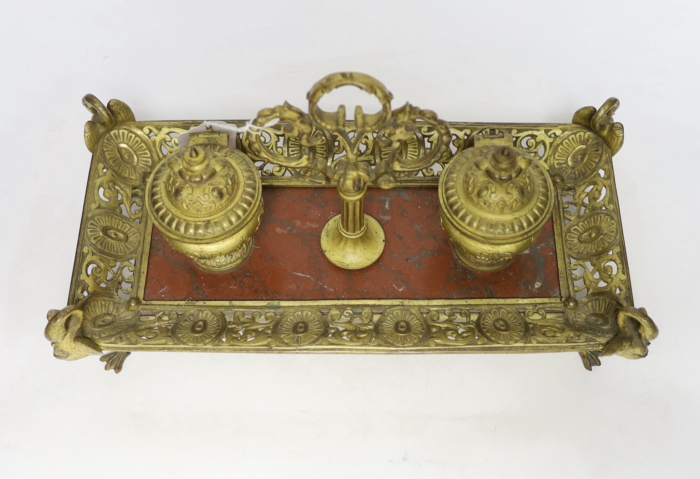 An ormolu inkstand with rouge marble base raised on four feet in the form of swans, 36cm wide